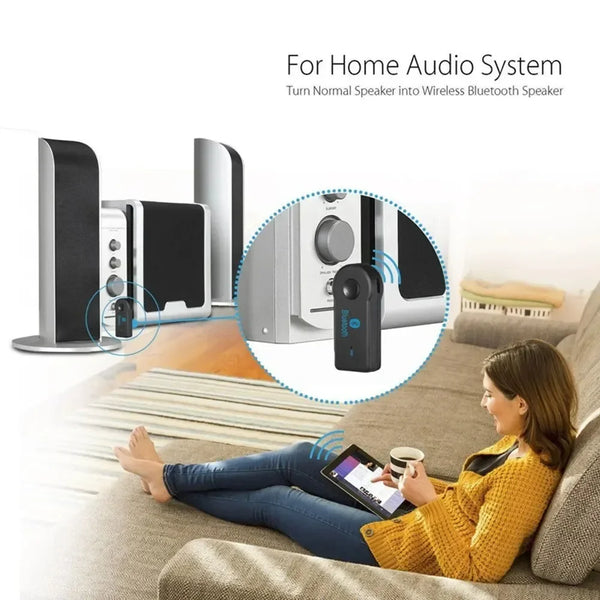 A woman is using a Bluetooth speaker to listen to music while relaxing on a couch.