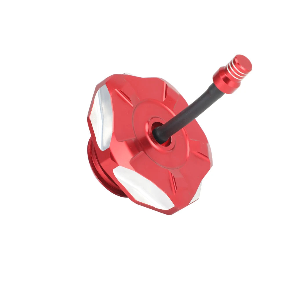 Red and silver aluminum fuel tank cap cover for a Honda CRF 110/125 motorcycle.