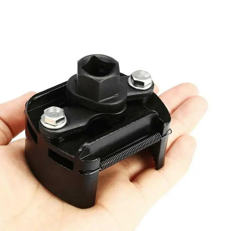 A black adjustable oil filter wrench with serrated jaws is held in a hand.