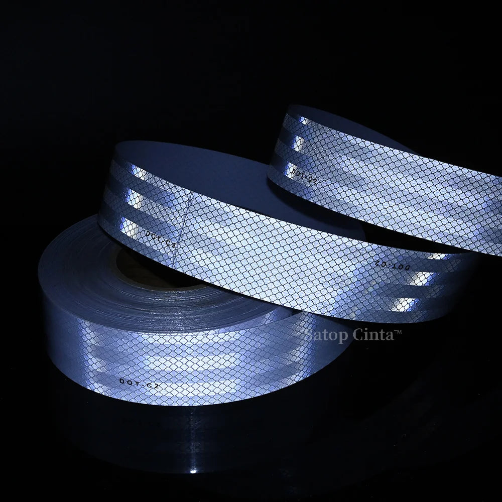 Rolls of high-visibility reflective safety tape are displayed against a dark background.