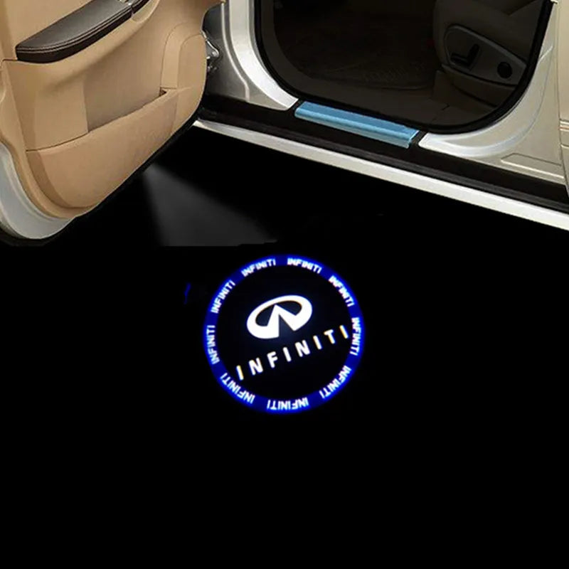 A close-up view of a car door interior showing a light projector illuminating the Infiniti logo.
