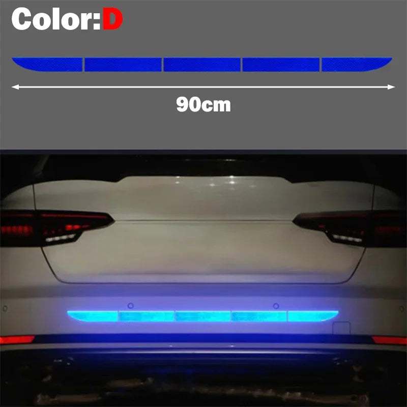A close-up view of a car's rear, showing blue reflective safety stickers applied to the license plate area.