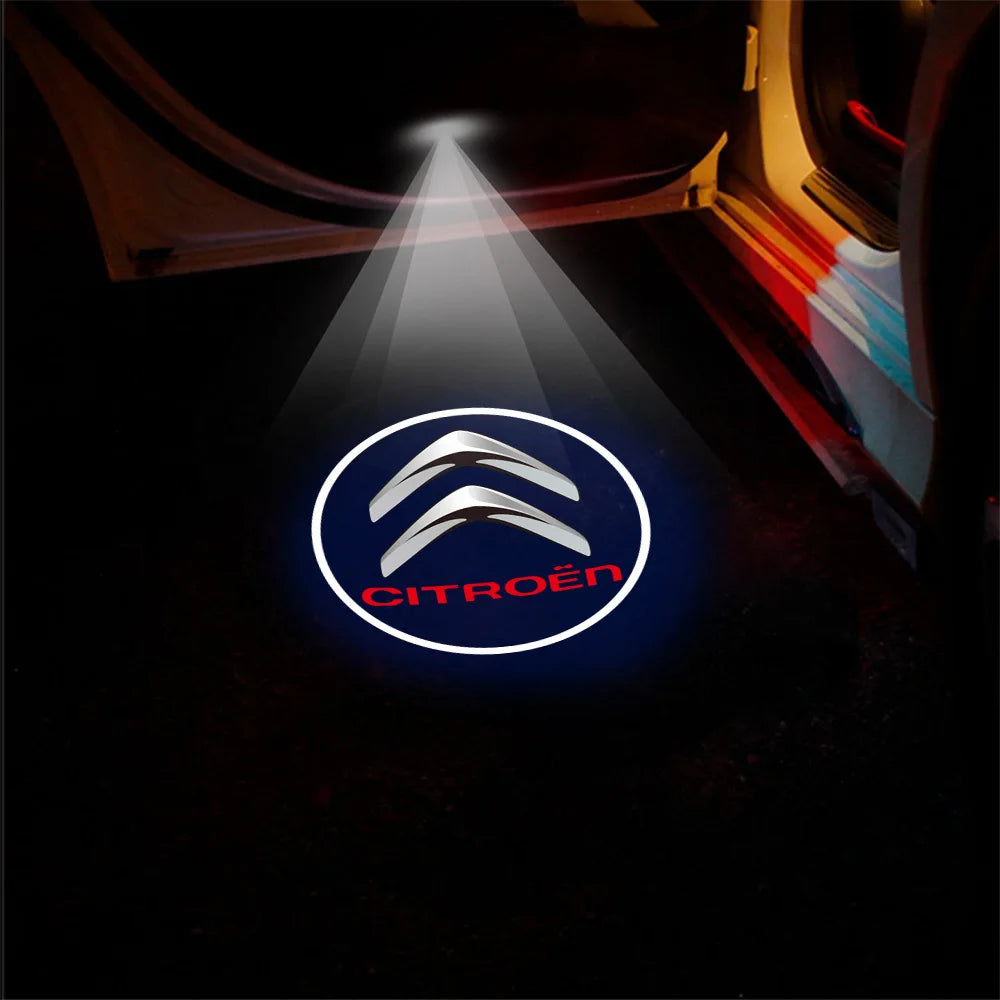 A white light beam projects the Citroën logo onto a dark surface, illuminating a car door entrance.