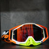 Orange and white high-performance motocross goggles resting on a dark surface.