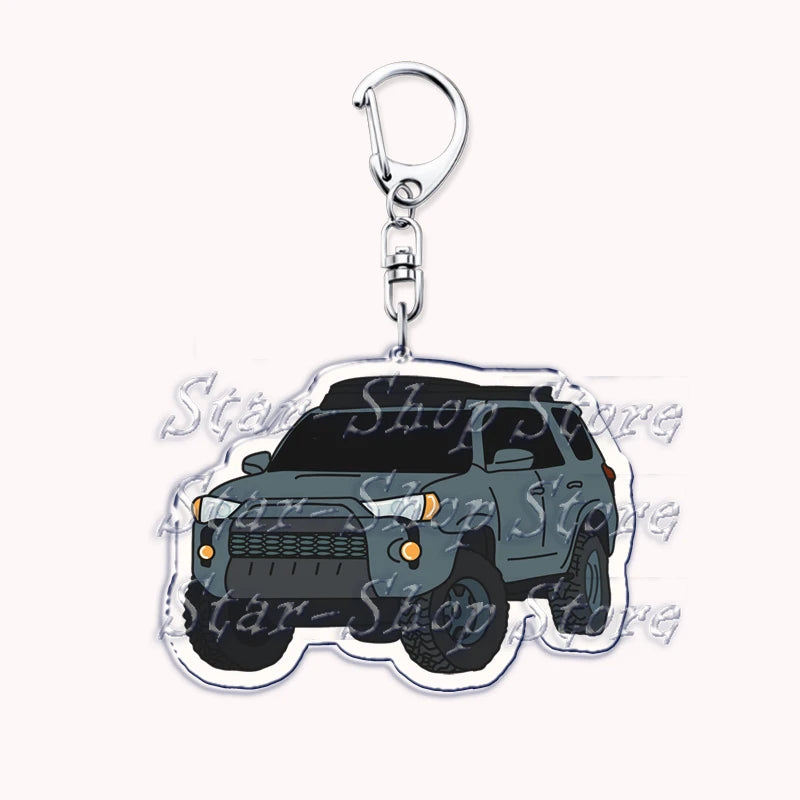 Silver acrylic keychain featuring a model of a dark gray off-road truck.