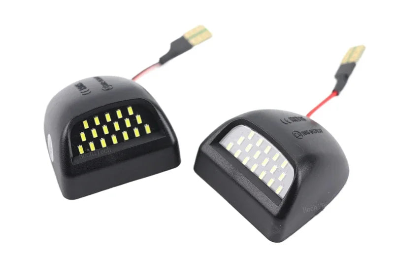 Dos luces de matrícula LED negras de alta intensidad con cables adjuntos.