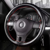 A close-up view of a black steering wheel with red stitching and an instrument cluster visible through the wheel.