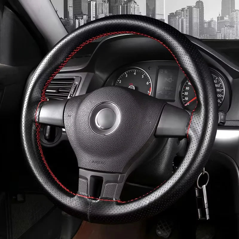 A close-up view of a black steering wheel with red stitching and an instrument cluster visible through the wheel.
