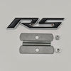 A silver and black RS emblem badge and two stainless steel bolts are displayed on a light gray background.