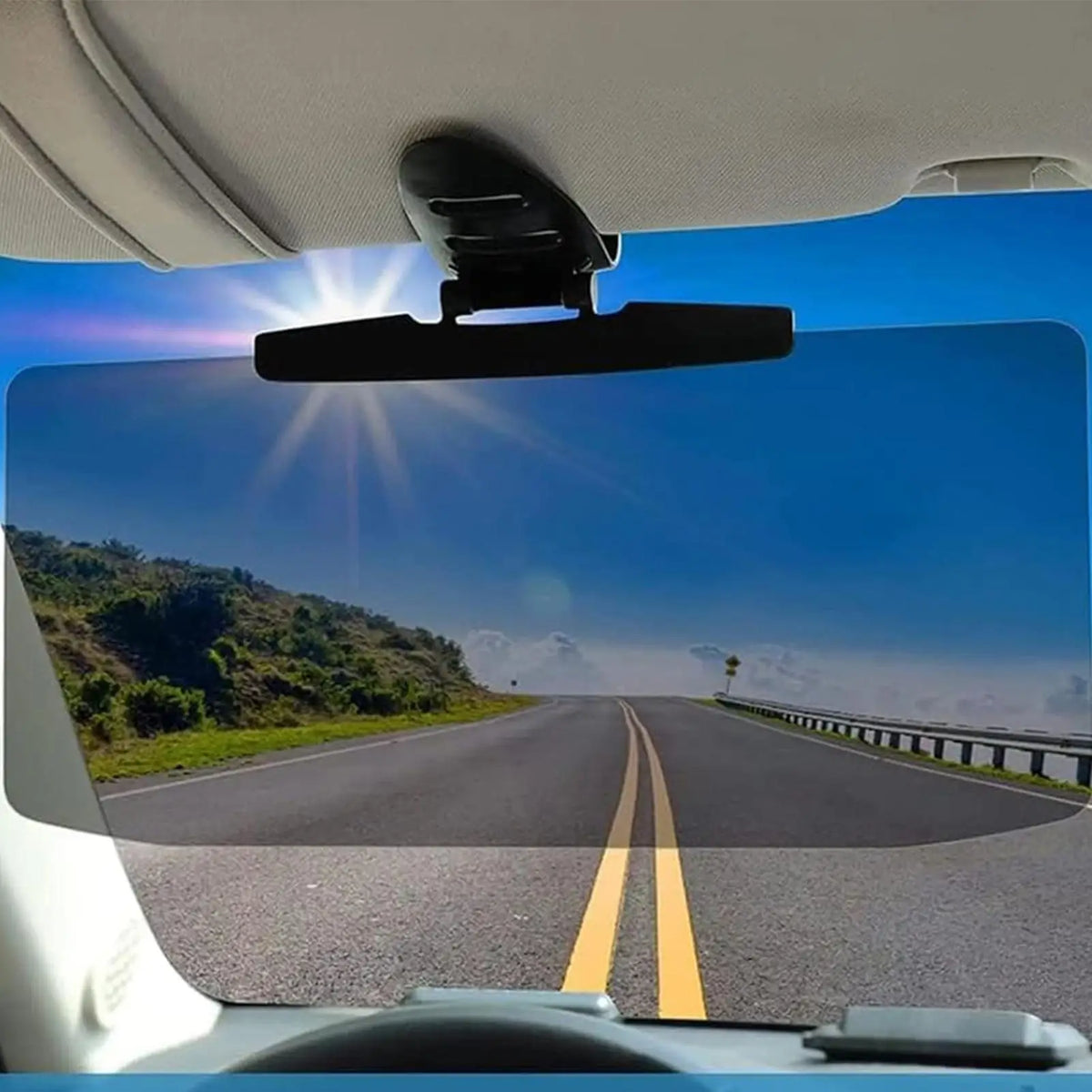 Vista interior de un coche mostrando un extensor de visera montado en el parabrisas con una vista panorámica de la carretera.