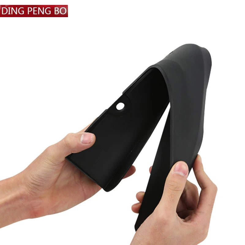 A hand is holding a black ABS mud flap designed for VW ID.4 or ID.6 vehicles.