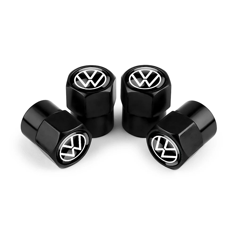 A set of black metal tire valve caps with VW logos displayed on a white background.