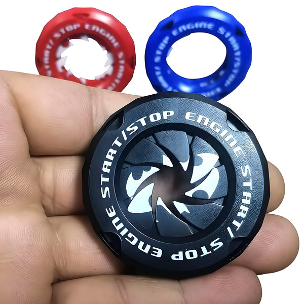 A hand holds three decorative car start button covers: red, blue, and black.