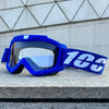 A bright blue windproof sports goggle with a white strap rests on a gray stone surface.