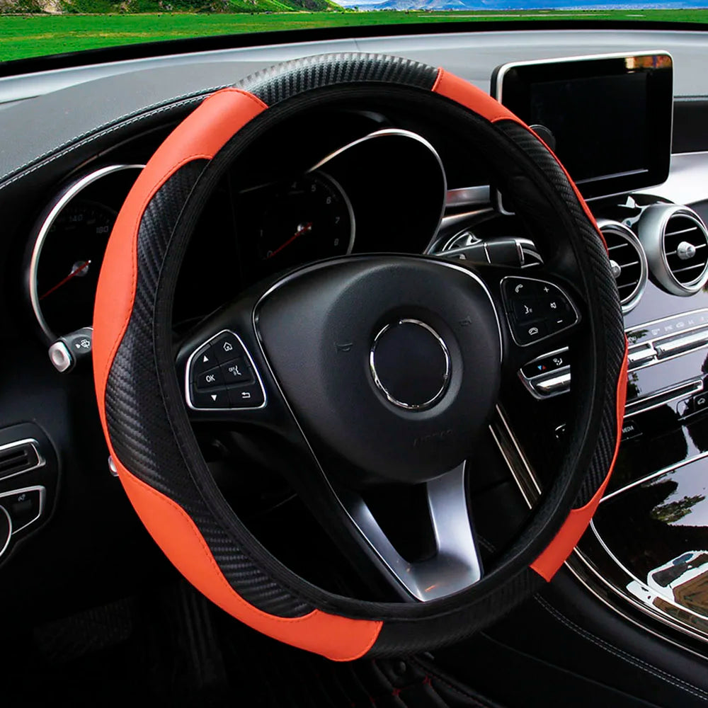 Orange and black PU carbon fiber steering wheel cover in a car interior