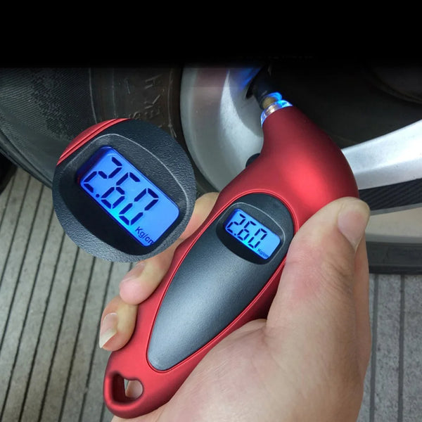 A hand holds a red digital tire pressure gauge displaying 2.60 kg/cn, positioned near a car tire.