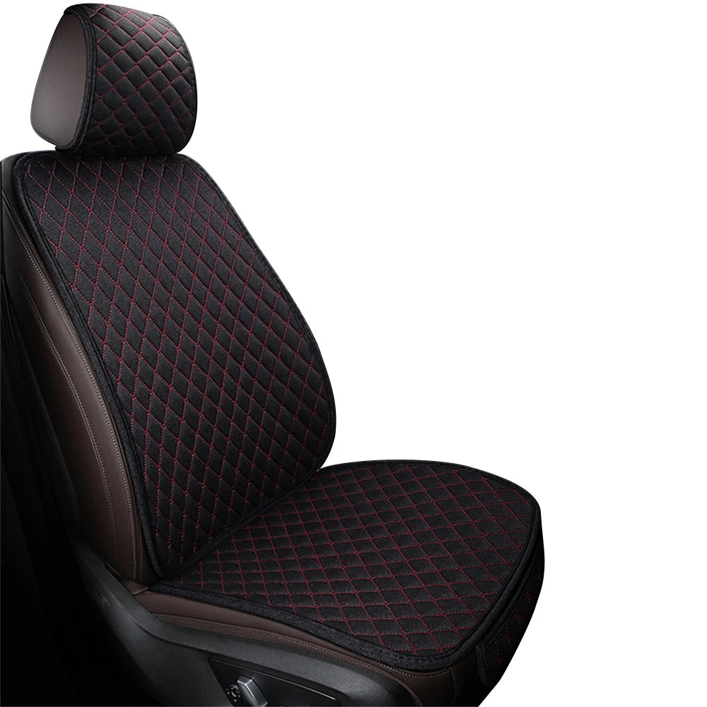 A close-up view of a black car seat featuring a quilted fabric pattern with red stitching.