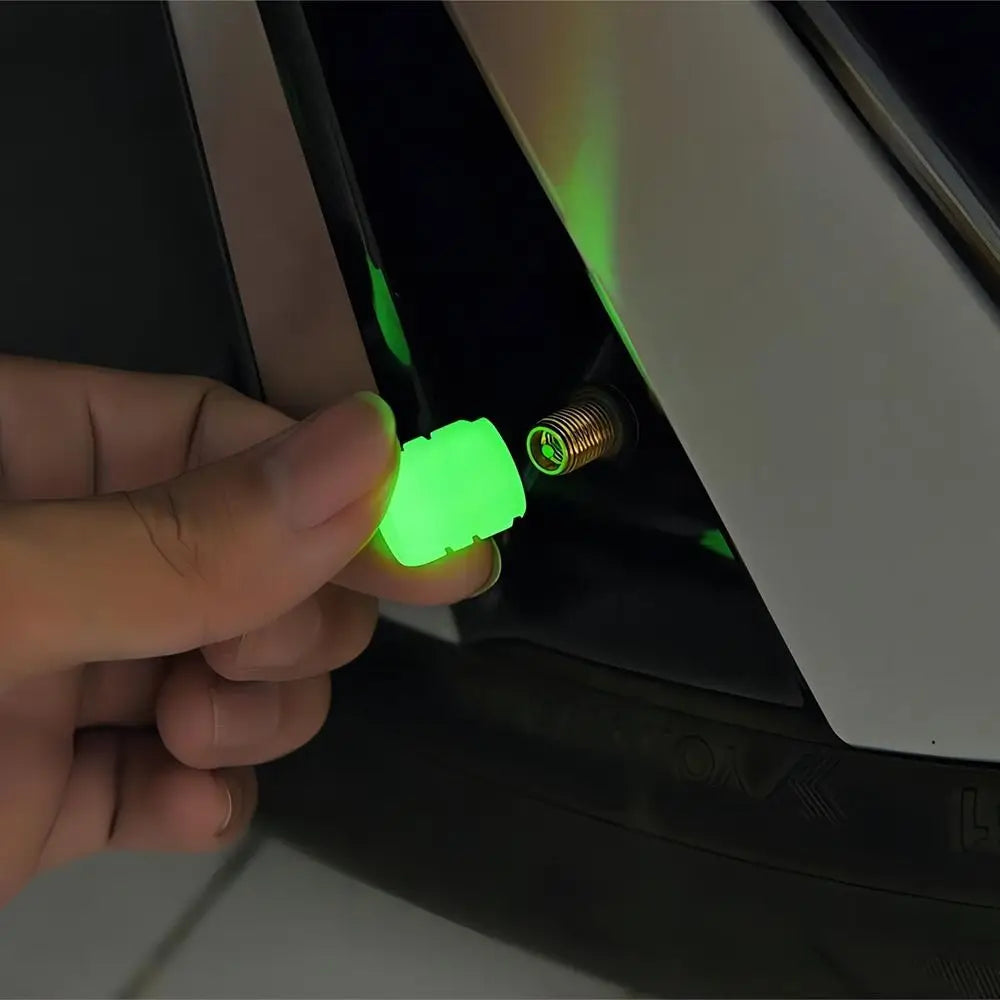 A hand is inserting a green luminous tire valve cap onto a metal fitting for a self-luminous tire valve cap.