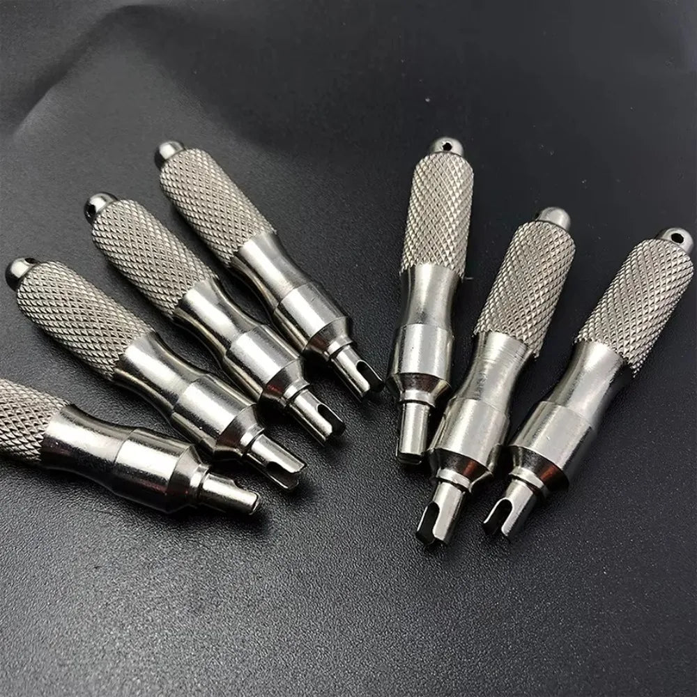 A collection of stainless steel tire valve core remover tools displayed on a dark background.