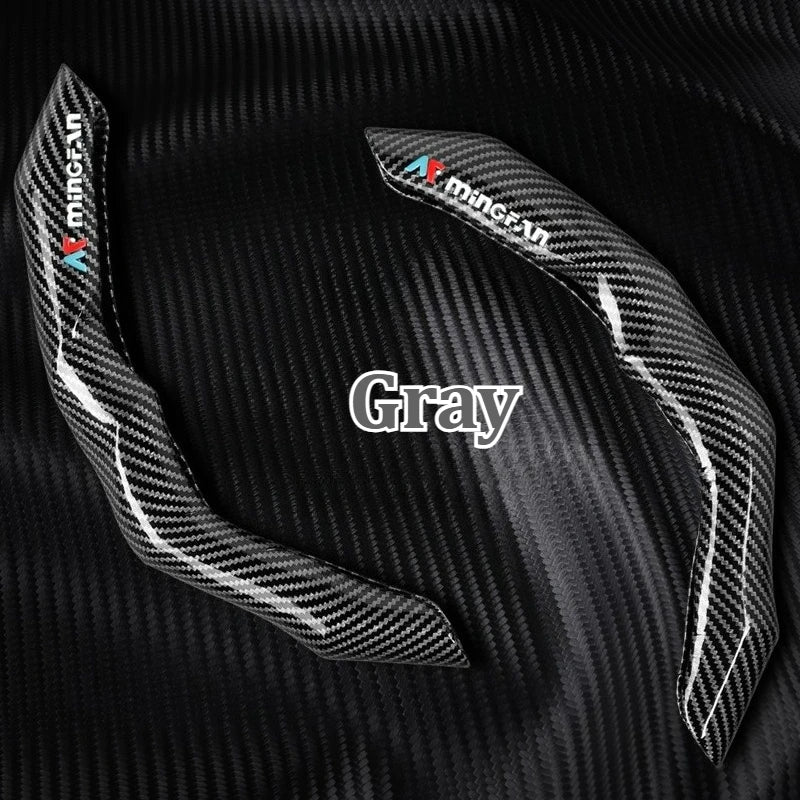 Gray carbon fiber steering wheel cover shown against a black carbon fiber background.