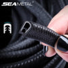 Une main tient un protecteur de rayures pour bord de porte noir, montrant sa surface texturée et son design.