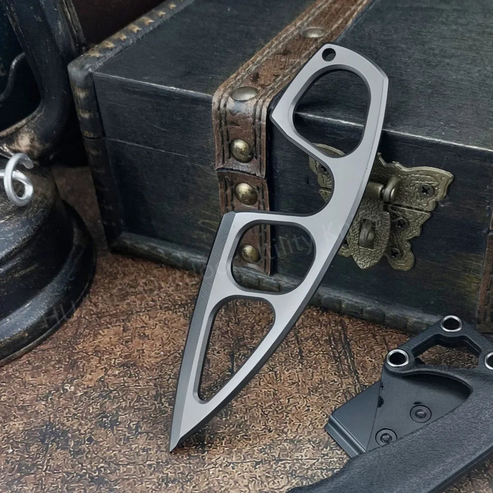 A stainless steel fixed blade survival knife with a curved blade and a handle resting on a wooden box.