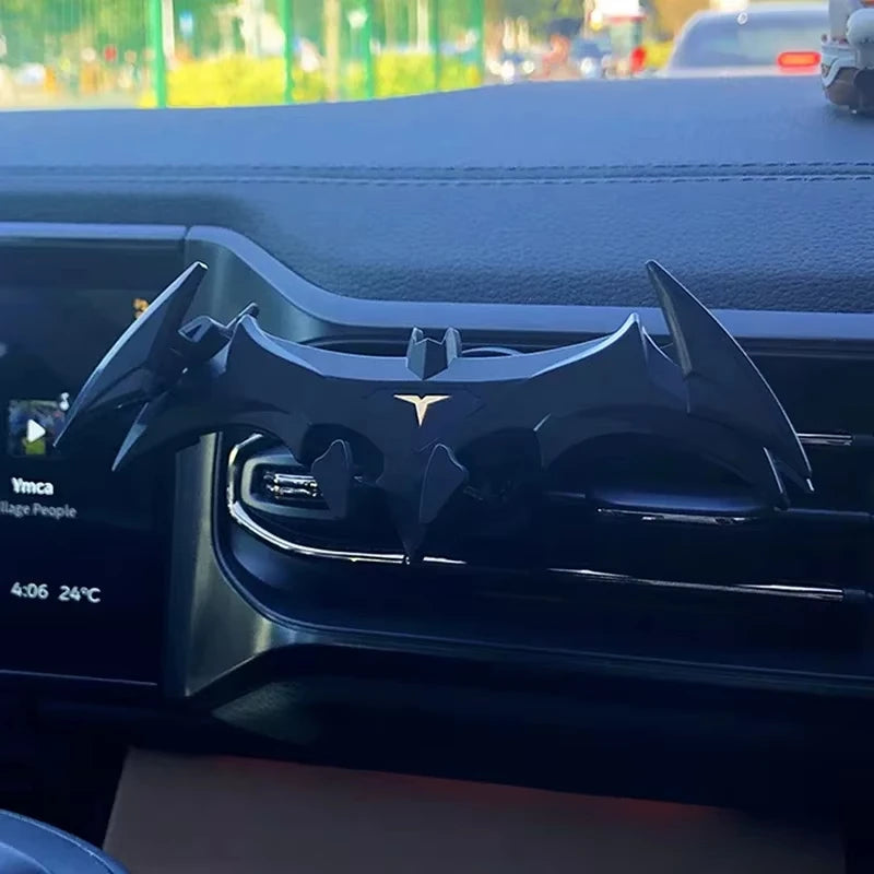 A black gravity expanding car phone holder mount is shown installed in a vehicle's interior console.