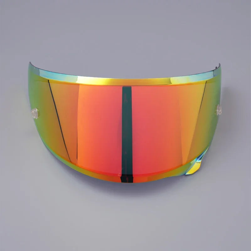 A curved, iridescent anti-fog visor for a motorcycle helmet, displaying a gradient of orange and green colors.