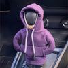 A purple cozy knit hoodie is shown resting on a car gear shift cover.