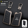 A black leather car key cover shell with a metallic finish shown next to a smart phone.