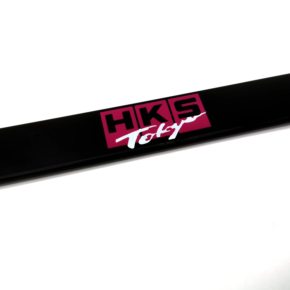 Black license plate frame decoration with pink text reading HKS Tokyo