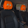 Two orange horror-themed car headrest covers with angry facial expressions installed in a vehicle interior.