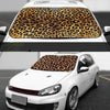 A white car with a leopard print sunshade installed on the front windshield.