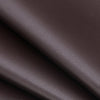 Primer plano de material de cuero PU marrón oscuro mostrando una textura suave y pliegue.