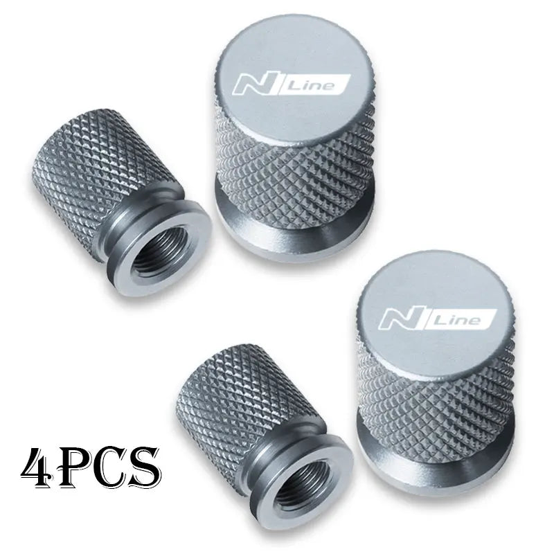 Set of four silver aluminum tire valve caps with textured surfaces and N Line branding