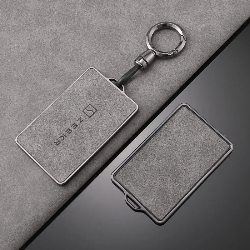 Un porte-clés avec une coque NFC argentée est posé sur une surface grise.