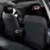 Two black eye print headrest covers are placed on the seats of a car.