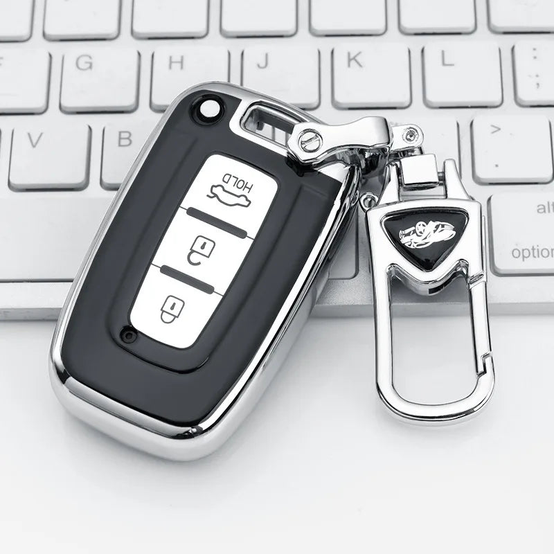 A black universal car key case cover with a silver clasp resting on a white keyboard.