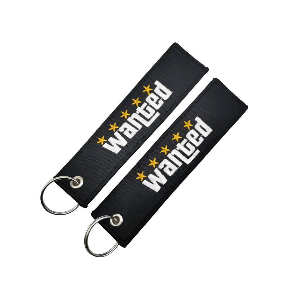 Porte-clés en nylon noir avec le mot 'wanted' brodé en étoiles jaunes
