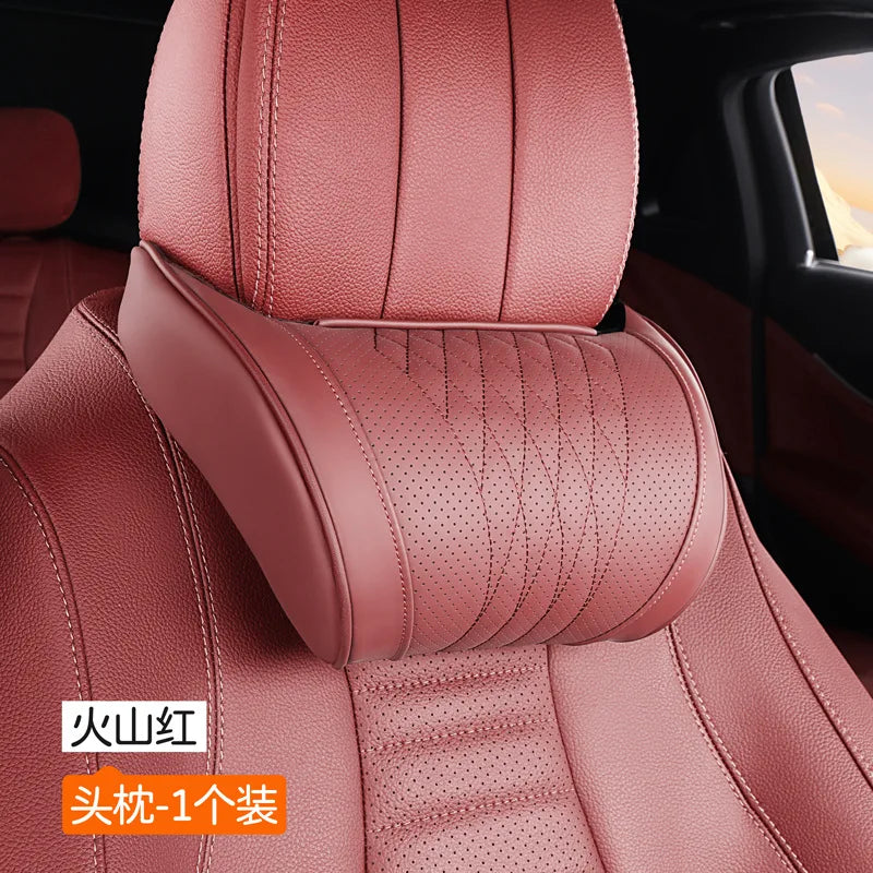 A close-up view of a pink leather car neck pillow with stitching and a dotted pattern.