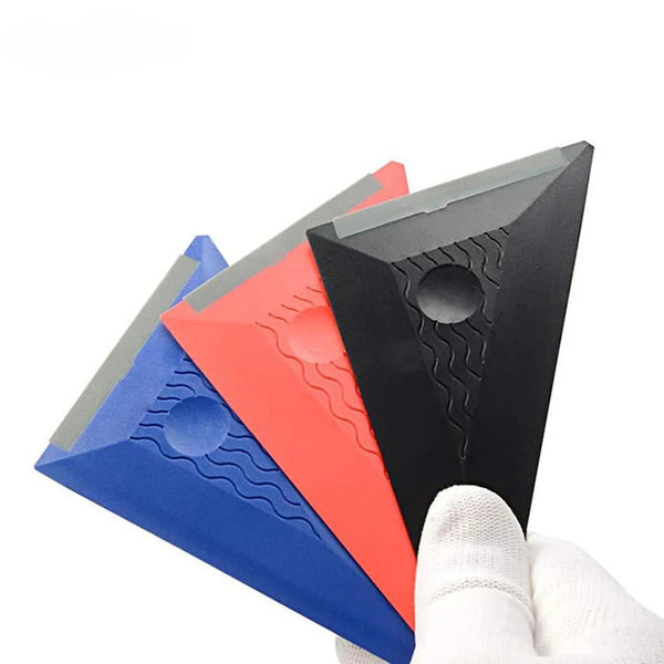A hand holds a multi-edge triangle squeegee tool with blue, red, and black edges.