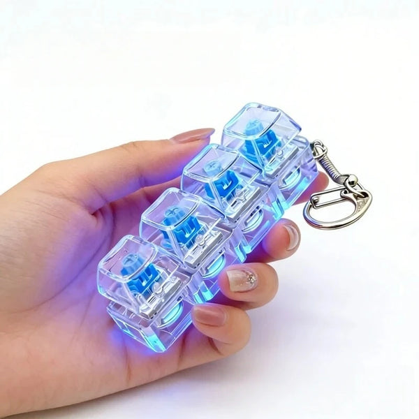 A hand holds a set of illuminated mechanical keyboard keychains with blue light.