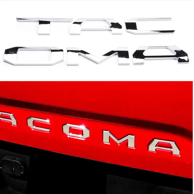 Silver 3D letter cover emblems for a Toyota Tacoma tailgate.