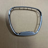 Cache de volant Chrome avec emblème sur une surface marron.