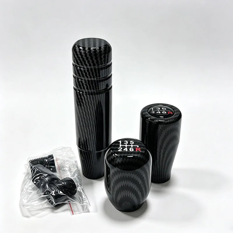 A black universal 5/6 speed manual gear shift knob is shown next to its packaging.