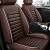 A close-up view of a brown leather car seat with stitching and a white accent stripe inside a vehicle.