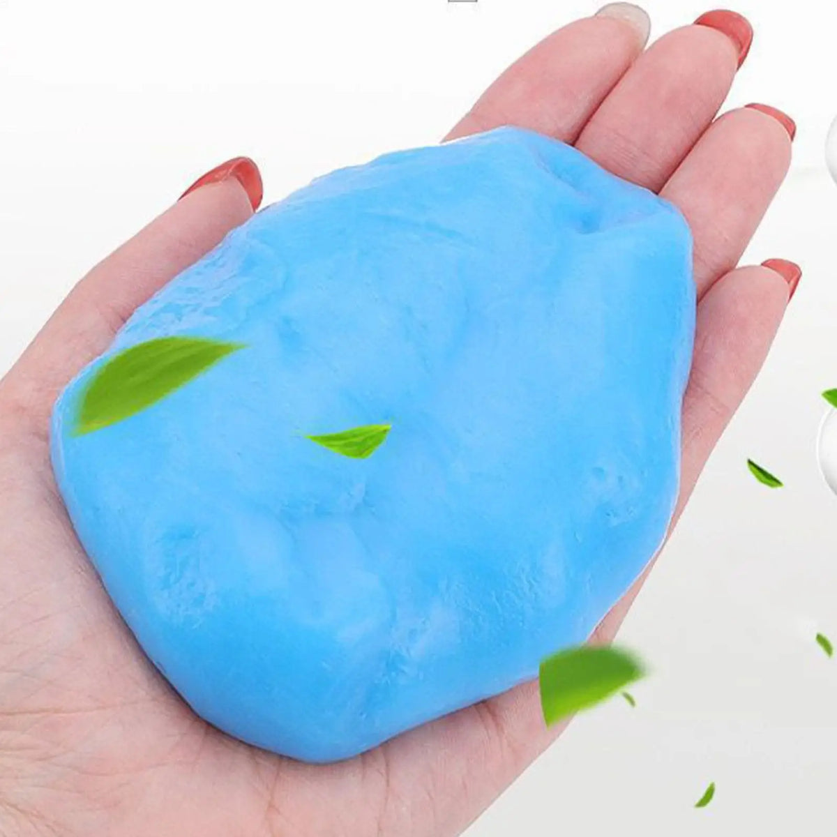 A hand holds a bright blue reusable car cleaning gel product with green leaves on it.