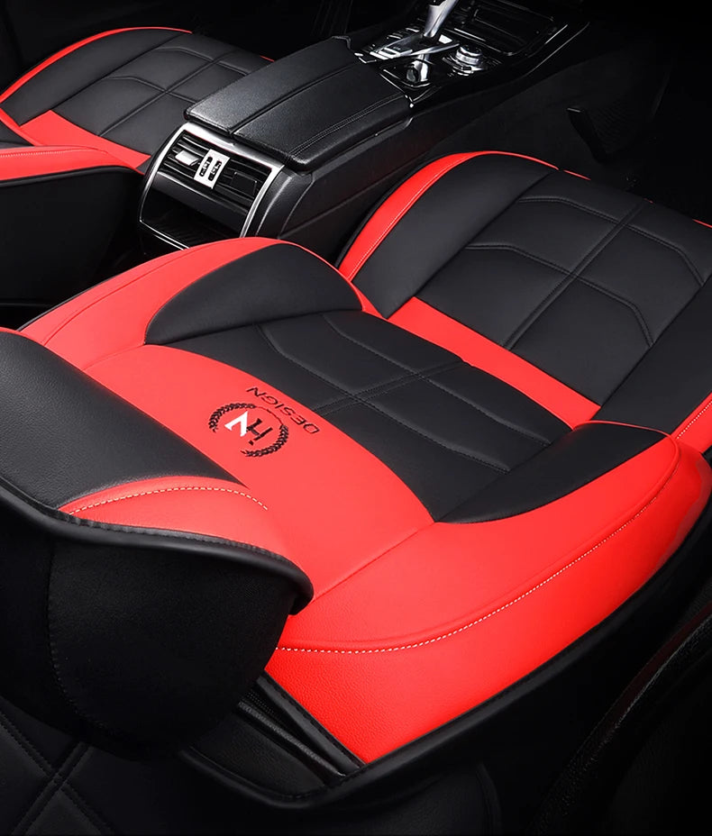 Red and black quilted car seat covers with a black console visible in a vehicle interior.