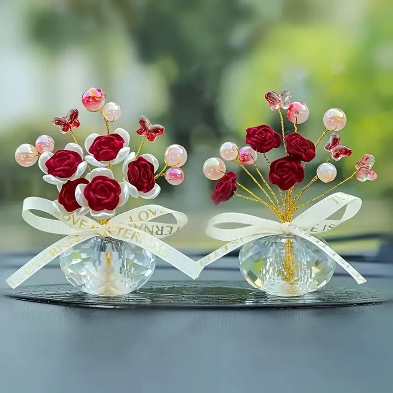 Crystal rose dashboard ornament featuring red and pink faux flowers tied with a white ribbon