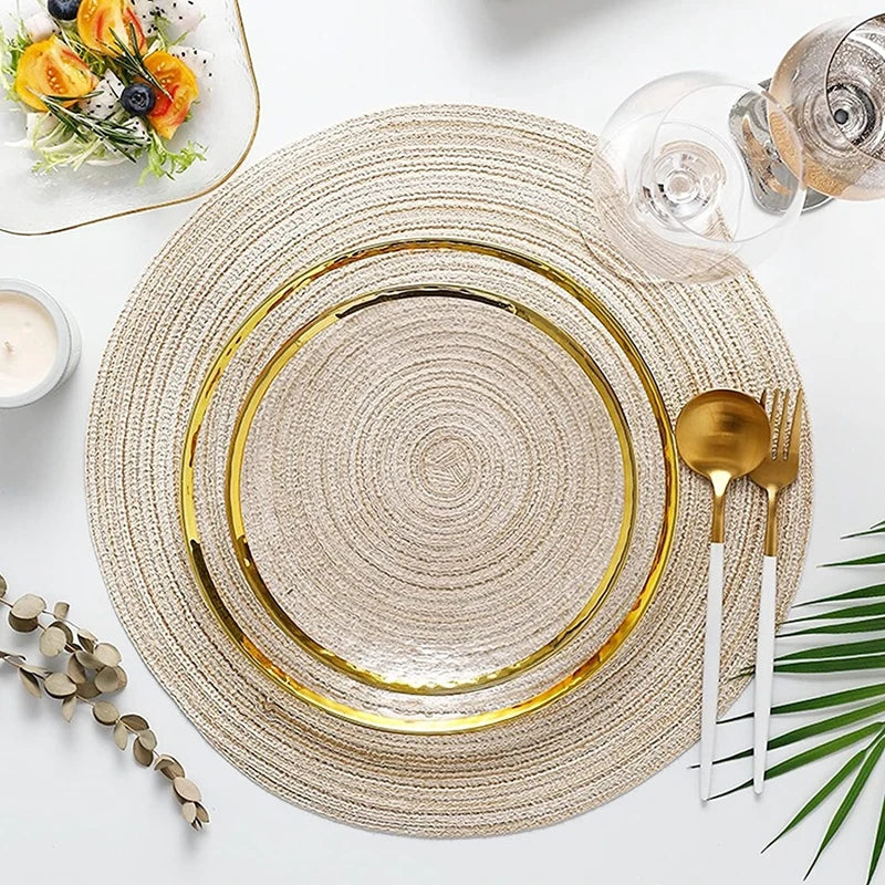 Un set de sous-plats et dessous-verres tressés ronds aux tons beige naturels avec des bords dorés et des accents vert olive.
